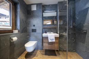 une salle de bains avec douche, toilettes et lavabo dans l'établissement Nationalpark Chalet Grosser Happ, à Neukirchen am Großvenediger 42 autres photos
