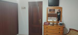 a bedroom with a dresser and a mirror on a dresser at Casa Rural & Parrillada Miguel in Lousame