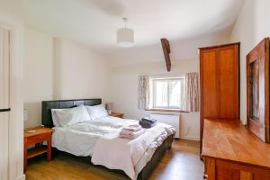 een slaapkamer met een bed, een bureau en een raam bij Grade II Old Engine House, on the SW Coast Path in Noss Mayo