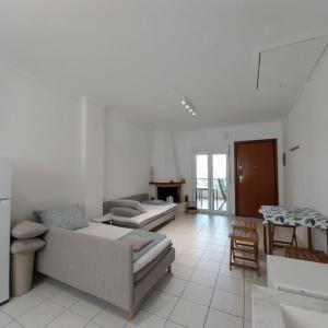 a living room with two beds and a table at Olive Tree Villa in Nikiti +11 photos