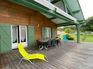 a deck with a table and chairs on a house at Villa landaise à 9km de l'Océan in Saint-Julien-en-Born