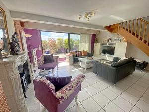 a living room with purple walls and a staircase at RÉF 353 appartement duplex Lorient centre in Lorient