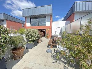 a courtyard with benches and plants in front of a building at RÉF 353 appartement duplex Lorient centre in Lorient