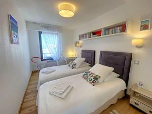 a bedroom with two beds with white sheets and a window at RÉF 353 appartement duplex Lorient centre in Lorient