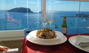 a plate of food on a table with a glass of wine at Apartmani Vila Marija in Budva