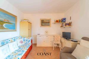 a living room with a couch and a desk with a tv at Family Flat - Casa vacanza ideale per famiglie in Olbia