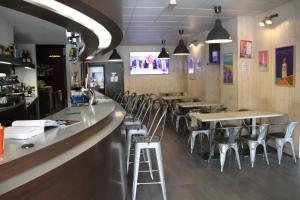 a bar with chairs and tables in a restaurant at Cit'Hotel Le Ch&ecirc;ne Vert in Les Sables-dʼOlonne