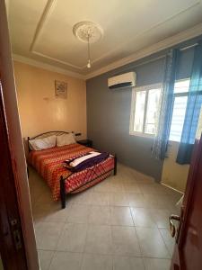 Un dormitorio con una cama con una manta roja y una ventana. en Medina 1, en Fez