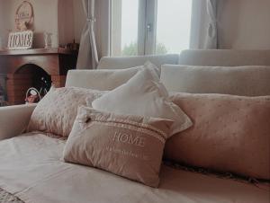 a pile of pillows on a couch with a fireplace at NiFe Tiny House - Secret Garden in Montalbo