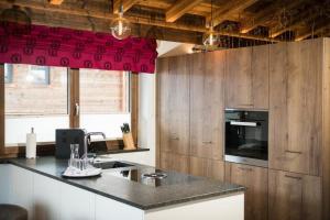 a kitchen with a counter top and a red curtain at Nationalpark Chalet Blessachkopf in Neukirchen am Großvenediger