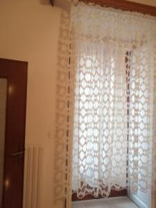 a window with a white lace curtain in a room at PROF OLIVETO ANTICo in San Marco in Lamis +84 photos