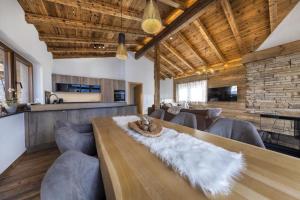 a living room with a long wooden table and couches at Nationalpark Chalet Hoher Sonnblick in Neukirchen am Großvenediger