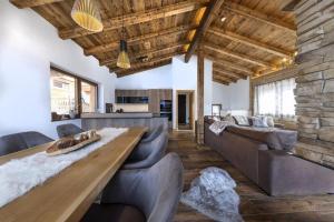 a living room with couches and a wooden table at Nationalpark Chalet Hoher Sonnblick in Neukirchen am Großvenediger +46 photos
