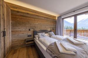 a bedroom with a bed with a wooden wall at Nationalpark Chalet Hoher Sonnblick in Neukirchen am Großvenediger