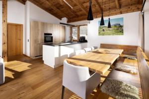 a kitchen and dining room with a wooden table and chairs at Nationalpark Chalet Blindis in Neukirchen am Großvenediger