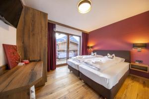 a bedroom with a large bed and a large window at Nationalpark Chalet Käferfeldeck in Neukirchen am Großvenediger