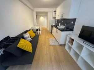 a living room with a black couch and a kitchen at Cardigos Village Apartments in Mação +33 photos