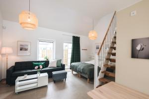 a living room with a couch and a bed at Mälarhusen Semesterby Österlen - Stugor & Gårdssviter in Sandby