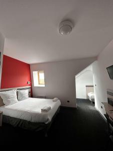 een hotelkamer met een groot bed met een rood hoofdeinde bij Brit Hotel La Ferté sous Jouarre in La Ferté-sous-Jouarre