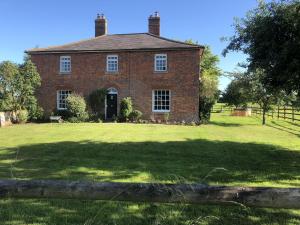 an old red brick house with a large yard at Mill Farm House in Devizes