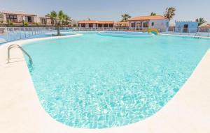 a large swimming pool with blue water at Casita Del Sol in Caleta De Fuste