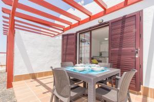 a dining room with a table and chairs on a patio at Casita Del Sol in Caleta De Fuste +6 photos