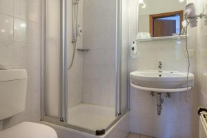 een badkamer met douche, wastafel en toilet bij Pension Alex in Bielefeld
