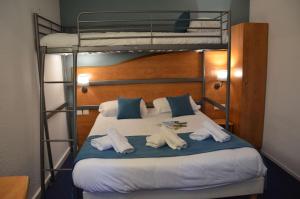 a bedroom with two bunk beds with towels on a bed at BRIT HOTEL Caen Hérouville in Hérouville-Saint-Clair +28 photos