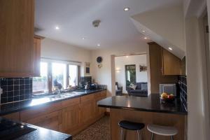 Una cocina con gabinetes de madera y encimera. en Perfect cottage retreat near the Brecon Beacons, en Llanwrda