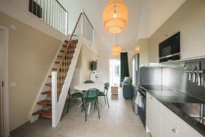 a kitchen and dining room with a table and a staircase at Mälarhusen Semesterby Österlen - Stugor & Gårdssviter in Sandby
