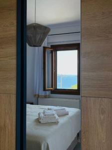 a small room with a bed with a window at A Fringe Of Blue in Ouranoupoli