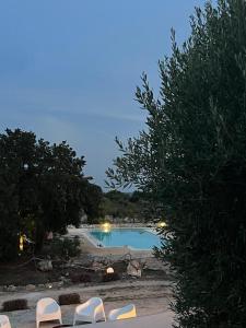 une piscine avec des chaises longues dans un complexe hôtelier dans l'établissement Trulli Colle Specchia Intera Villa, à Cisternino
