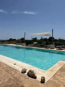 - une piscine avec des rochers au milieu dans l'établissement Trulli Colle Specchia Intera Villa, à Cisternino