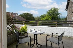 a table and two chairs sitting on a balcony at The Lakehouse Rooms at The Waterhead Inn, Ambleside in Ambleside