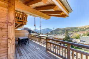 a wooden deck with a table on top of it at Homency - Résidence de l'Alpe 308 in L'Alpe-d'Huez