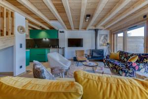 a living room with couches and a kitchen at Homency - Résidence de l'Alpe 308 in L'Alpe-d'Huez