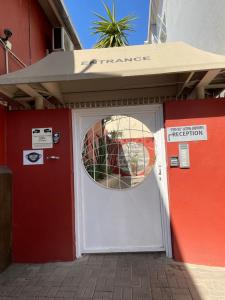 a white door with a circular window on a building at Stern self catering apartments in Windhoek