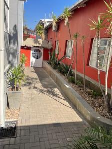 a red house with palm trees in front of it at Stern self catering apartments in Windhoek