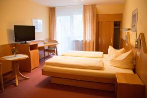 a hotel room with a bed and a desk at Hotel Restaurant Löwen in Zell im Wiesental