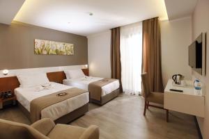 ein Hotelzimmer mit 2 Betten und einem Stuhl in der Unterkunft Buca Residence Hotel in Izmir