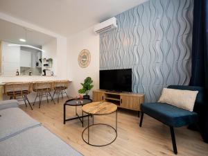 a living room with a couch and a tv and a bar at Torremolinos Centro Apartamento con parking y playa a 5 min, wifi alta velocidad in Torremolinos