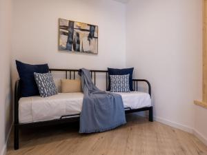 a couch with blue and white pillows in a room at Torremolinos Centro Apartamento con parking y playa a 5 min, wifi alta velocidad in Torremolinos