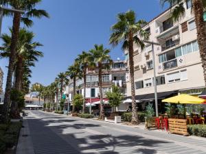 a street with palm trees and a building at Torremolinos Centro Apartamento con parking y playa a 5 min, wifi alta velocidad in Torremolinos