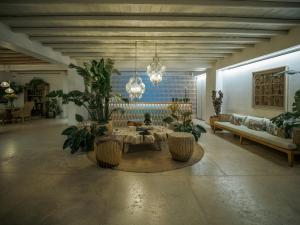 a living room with a table and some plants at Asty Mykonos Hotel & Spa - World of One Hotel Group in Mýkonos City