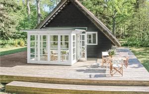a house with a wooden deck with a table and chairs at Holiday Home Stængestykket in Udsholt Sand