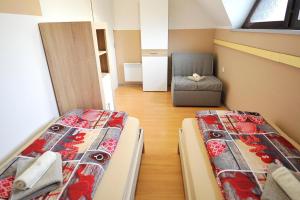 two beds in a small room with a chair at Aparthouse SUPREME with Terme Catez Swimming Pools Tickets in Čatež ob Savi