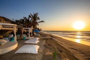 a group of pillows on the beach at sunset at DCO Suites Lounge & Spa in Máncora