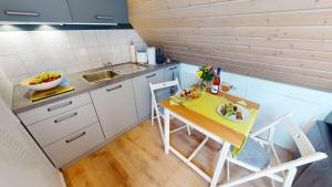 a small kitchen with a small table and chairs at Skyloft Seeliebe in Markelfingen +8 photos