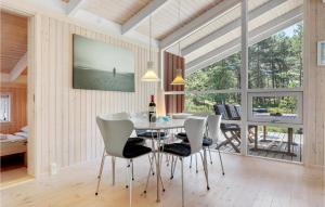 a dining room with a table and white chairs at Godt Gemt in Vester Sømarken