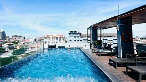 a swimming pool on the roof of a building at The Base Inn Pattaya in Pattaya